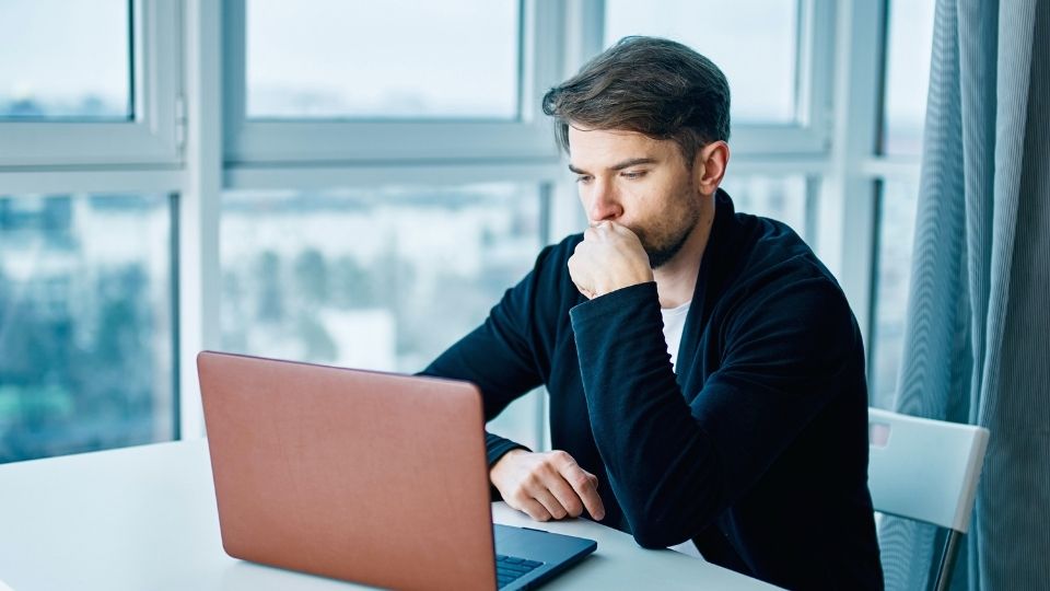 a man on his laptop looks up how Naltrexone and Vivitrol for Alcohol Use Disorder can help with drinking problems.